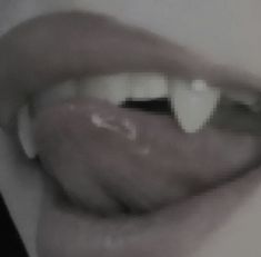 a woman's lips with white teeth and black tips