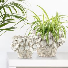 two ceramic planters sitting on top of a white table