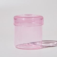 a pink glass jar sitting on top of a white table