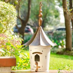 a bird house sitting on top of a wooden bench