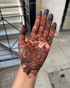 a woman's hand with henna tattoos on it