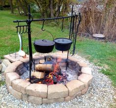 an outdoor fire pit with pots and pans on it