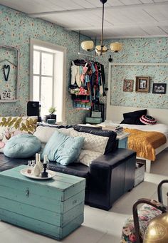 a living room filled with lots of furniture next to a bed and dresser in front of a window