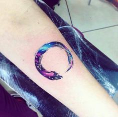 a person with a tattoo on their arm that has a circular design in the middle