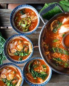 four bowls of soup on a wooden table