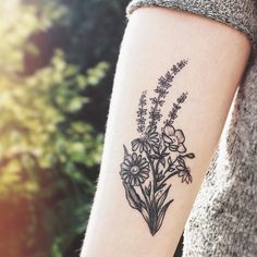 a woman with a flower tattoo on her arm