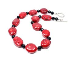 This custom handcrafted red statement necklace features magnificent flat oval red coral beads, which have a wonderful natural earthy texture to them, separated by small round faceted black onyx beads. The red and black creates a dramatic look that is both fun and easy to wear - gorgeous! The Handmade Round Red Coral Beaded Necklaces, Handmade Red Oval Necklace, Red Coral Oval Bead Jewelry As Gift, Oval Beads Red Coral Jewelry Gift, Handmade Red Coral Oval Beads Jewelry, Handmade Red Coral Jewelry With Oval Beads, Handmade Oval Beads Red Coral Jewelry, Red Beaded Necklaces With Natural Stones, Red Oval Gemstone Bead Jewelry