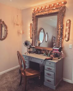 a desk with a mirror, chair and lights on top of it in a room