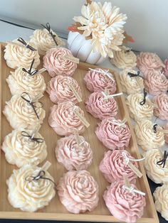 cupcakes with pink frosting on a wooden tray