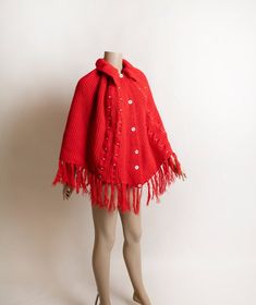 FREE DOMESTIC SHIPPING! <3♥ Bright & cheery red knit poncho with a fringe hem!♥ Buttons up the front, folded large collar! ♥ White accents in the cable-like knit! ♥ In great condition! No label tags. * measurements *About 26" across the bust areaLength - 21" with a 5" fringe on the bottom (so 26" in total)** I do ship worldwide!For more vintage cuteness, check out my store:→ http://zwzzy.etsy.com ←❀ Instagram - Zwzzy❀ Twitter - http://www.twitter.com/zwzzy❀ Facebook - http://www.facebook. Red Knit Outerwear With Buttons, Red One-size Poncho Cape, Red One-size Cape Poncho, Red One Size Cape Poncho, Red Long Sleeve Poncho, One Size, Red Cozy Acrylic Outerwear, Red Winter Cape One Size, Red Knitted Outerwear, One Size Red Knitted Outerwear