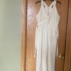 White Sleeveless Jumpsuit With Wide Pant Leg. Front Had A Cross Cross Style. Attached Belt And Pockets On Each Side. Zip Up Back Sleeveless Linen Jumpsuits And Rompers For Day Out, Sleeveless Linen Jumpsuits For Day Out, Sleeveless Linen Summer Jumpsuits And Rompers, Sleeveless Linen Jumpsuit For Summer, Sleeveless Linen Summer Jumpsuit, Beige Sleeveless Jumpsuits And Rompers For Loungewear, White Sleeveless Jumpsuit, Womens Palazzo Pants, Cropped Wide Leg Pants