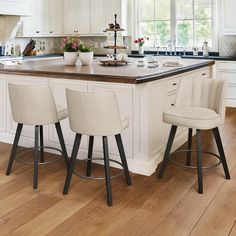 a kitchen island with three stools in front of it