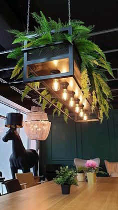 a wooden table topped with lots of plants and hanging light fixture above it's head