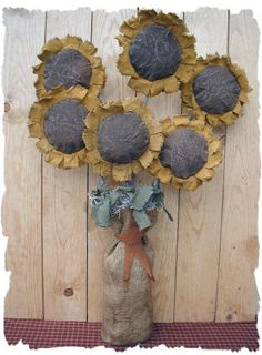 a vase filled with sunflowers sitting on top of a wooden floor next to a wall