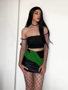 a woman with long black hair wearing fishnet stockings and holding her hands on her hips