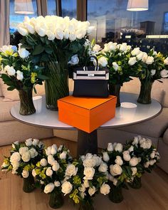 three vases filled with white flowers on top of a table