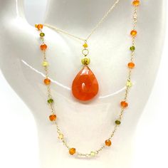 "Wire, Chain & Clasp: 14k Gold Stones: Carnelian Drop (approx. 18mm), Carnelian Bead (approx. 1mm x 2mm), 18k Gold Nugget (approx. 4mm) Necklace Length: approx. 17\" Backdrop: Freshwater Pearl & Tsavorite Backdrop Length: 1.75\" ------------------------------------------------------------ Let me know if you have any questions! *Size adjustable at client's request" Handmade Carnelian Yellow Gold Jewelry, Handmade Yellow Gold Carnelian Jewelry, Artsy Yellow Gold Jewelry With Carnelian Stones, Orange Briolette Jewelry For Gift, Artisan Carnelian Gold Necklace, Orange Carnelian Gemstone Necklace, Orange Faceted Carnelian Necklaces, Orange Faceted Carnelian Necklace, Orange Carnelian Hand-strung Necklace