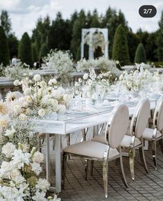 the table is set with white flowers and place settings for guests to sit down at