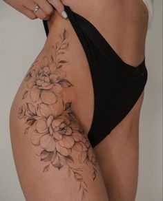 a woman's lower body with flowers on her stomach and the bottom half of her panties