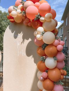 an arch decorated with balloons and greenery