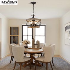 a dining room table with chairs and a chandelier hanging from it's ceiling