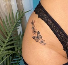 a woman's stomach with butterflies on it and a plant in the back ground