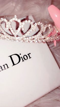 a tiara sitting on top of a book with the word queen dior written in it