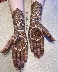 two hands with henna designs on them