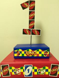 a cake made to look like an unopened pizza box with the number one on top