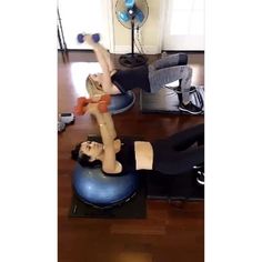 a woman is doing exercises on an exercise ball in the living room with her legs up