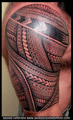 a man's shoulder with an intricate tattoo design on it