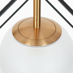 a white and gold lamp with black lines in the background