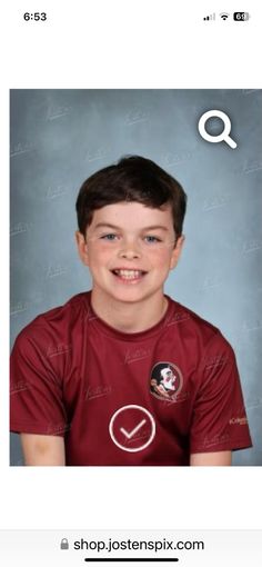 a young boy is smiling and wearing a red shirt with the word q on it