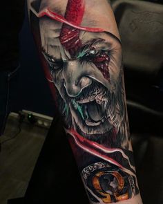 a man's arm with an evil clown tattoo on it