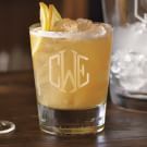 a close up of a drink on a table with ice and lemon wedges next to it