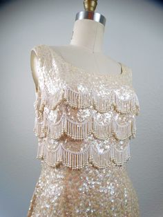 Glamorous Wedding Flapper Dress With Rhinestone Fringe, Glamorous Fringe Flapper Dress For Wedding, Cream Embellished Sequin Fabric For Party, Embellished Cream Sequin Fabric For Party, Cream Embroidered Sequin Fabric For Party, Cream Sequin Fabric For Party, Sleeveless Sequined Flapper Dress For Wedding, Vintage Sequin Dress For Wedding, 60s Bombshell