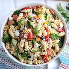 a white bowl filled with pasta salad on top of a table