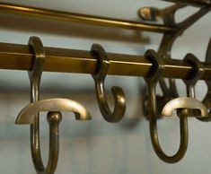 three metal hooks hang on a wall