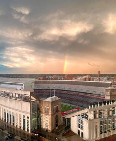 a rainbow shines in the sky over a stadium