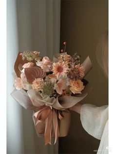 a woman holding a bouquet of flowers in her hand