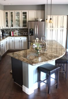 a kitchen island with two stools in front of it