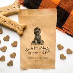 a brown paper bag sitting on top of a table next to two bone shaped treats