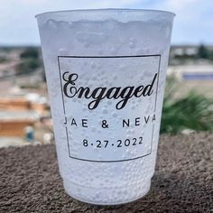 a close up of a plastic cup with water on the bottom and an engaged label