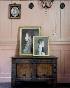 an old dresser with two pictures on it