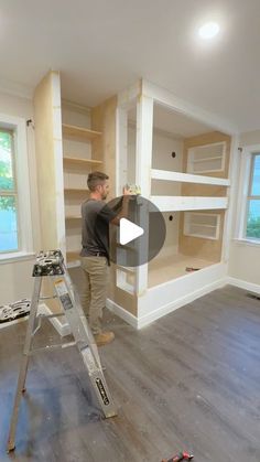 a man standing on a ladder in a room