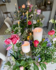 the table is set with flowers and candles