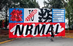 a person walking past a large sign with words on it