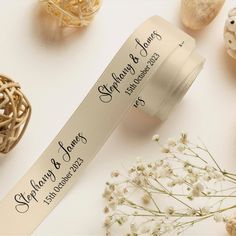 a roll of white satin ribbon next to some flowers and seashells on a table