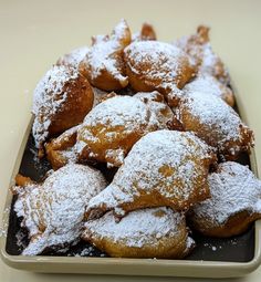 powdered sugar covered pastries in a tray