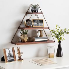 a shelf with pictures and other items on it next to a vase filled with flowers